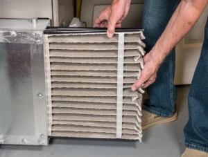 HVAC tech replacing a dirty filter to prevent a furnace blowing cold air