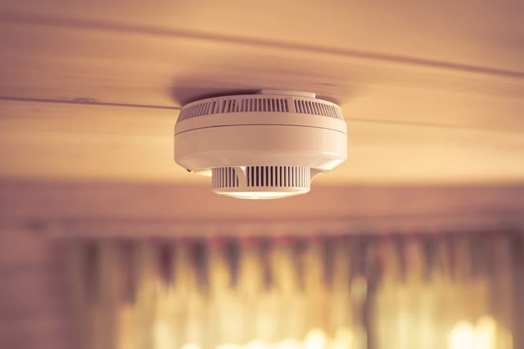 Carbon monoxide detector on a ceiling inside a home, used to detect CO levels when a carbon monoxide detector is beeping